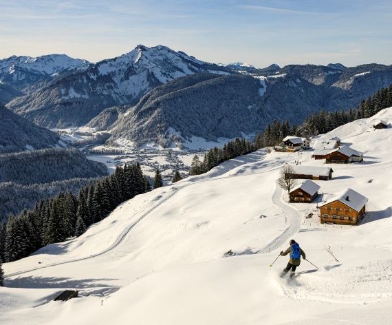 Skifahrer auf der Piste in Voralberg mit Bergsicht
